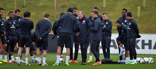 England manager Roy Hodgson (C) talks to his players during a training session near Burton-upon-Trent, on March 19, 2013